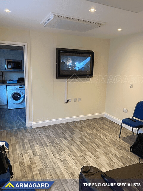 A wall-mounted anti-ligature TV cabinet in a supported living environment