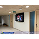 A hallway installed 65" anti-ligature TV cabinet within a youth facility