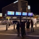 Improve Wayfinding with IP56 Rated Outdoor LCD Enclosures at Transport Hubs Travellers checking live departure times on four 47-inch outdoor LCD enclosures outside Schiphol Airport