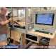 A desk-mounted industrial computer workstation in a woodworking workshop
