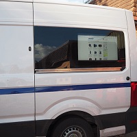 Van-side digital 32" screen mounted in the back of a work van